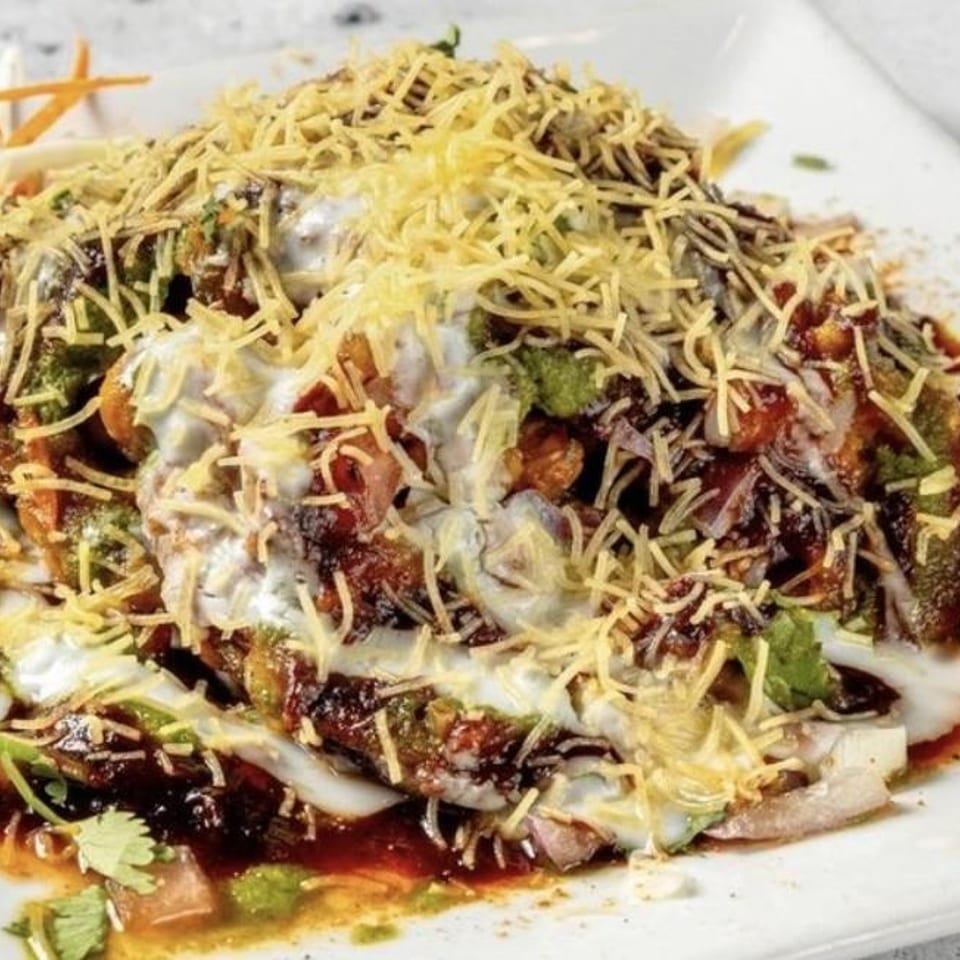 Chaat topped with yogurt, chutney and sev.