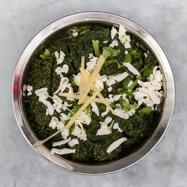 Palak Paneer, a vibrant green Indian spinach dish with paneer cheese, ginger, and cilantro.