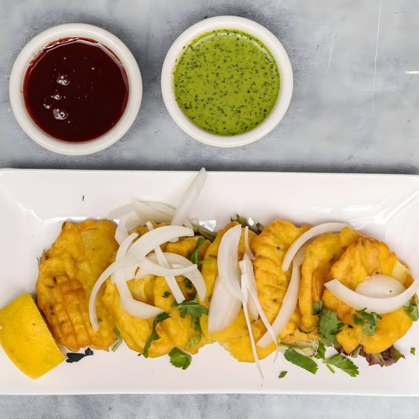 Chakra Indian Cuisine's fried Indian fritters with onions, cilantro, lemon, and two dipping sauces.