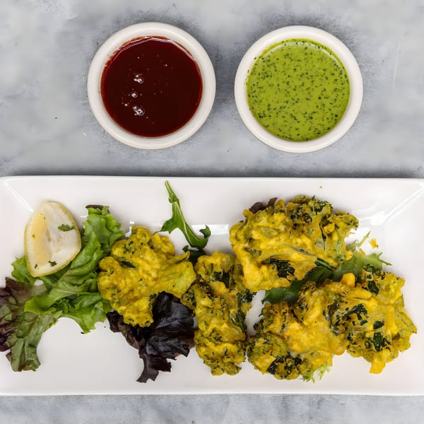 Chakra Indian Cuisine's broccoli pakora with lemon, lettuce, and two dipping sauces.